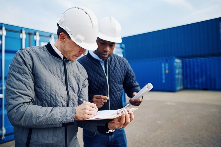 Maestrías y MBA dos-ingenieros-revisando-listas-de-inventario-en-un-muelle ¿Quién es un consultor en logística y transporte?  