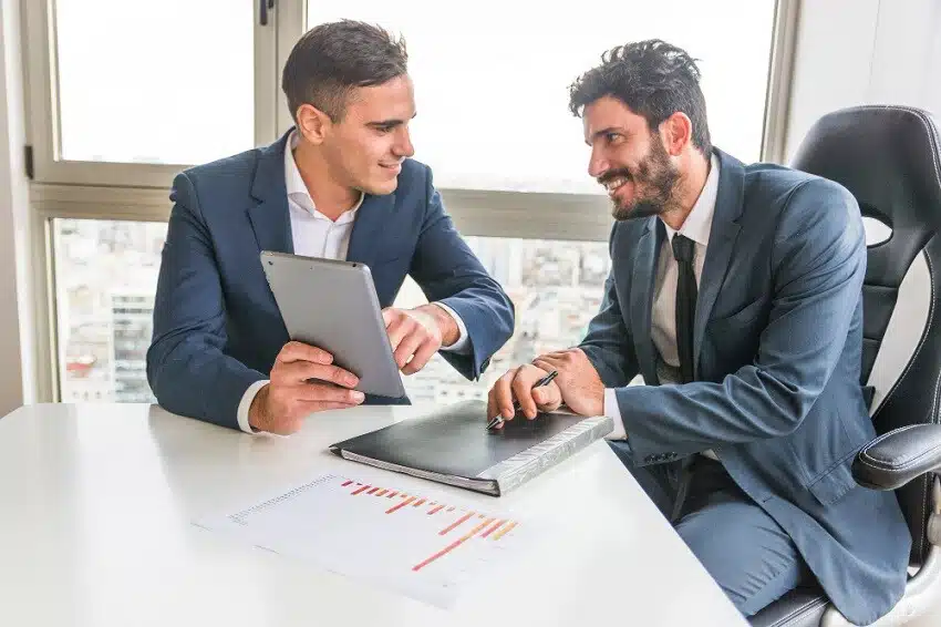 Maestrías y MBA empleado-masculino-que-muestra-a-su-companero-tableta-digital ¿Quién es un consultor de negocios?