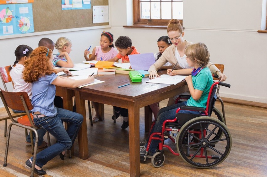 Maestrías y MBA maestra-ayudando-a-los-alumnos-en-el-aula Desafíos y estrategias de la inclusión educativa  