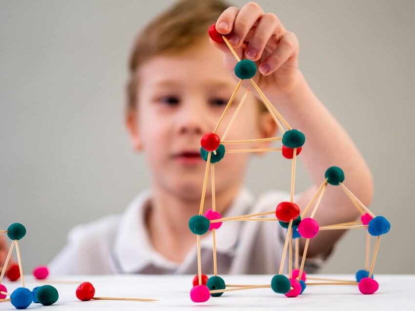 Maestrías y MBA nino-jugando-colorido-juego-atomos-mesa Principios de la neurociencia en el aula  