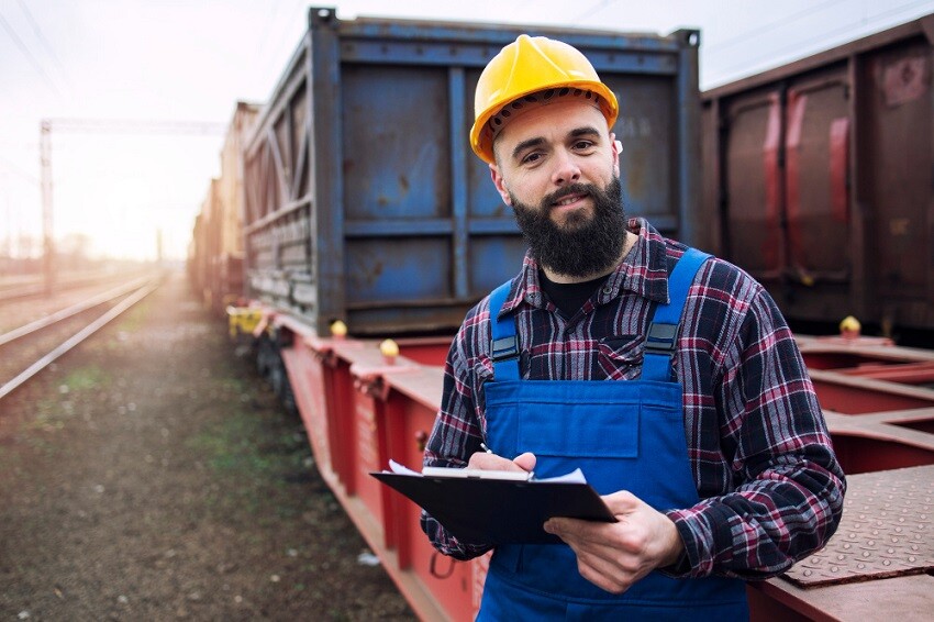 Maestrías y MBA retrato-trabajador-transporte-portapapeles-envio-contenedores-carga-ferrocarril Funciones del gerente de logística y transporte  